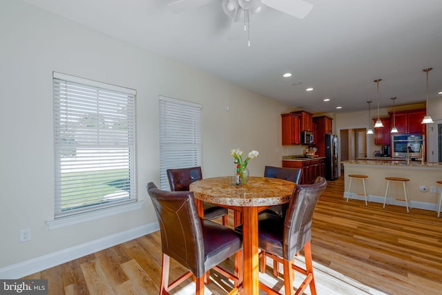 dining room with light hardwood / wood-style flooring and ceiling fan