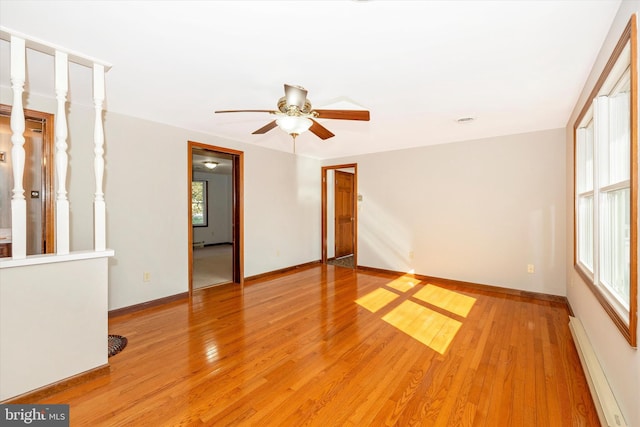 spare room featuring ceiling fan, hardwood / wood-style flooring, and a baseboard radiator