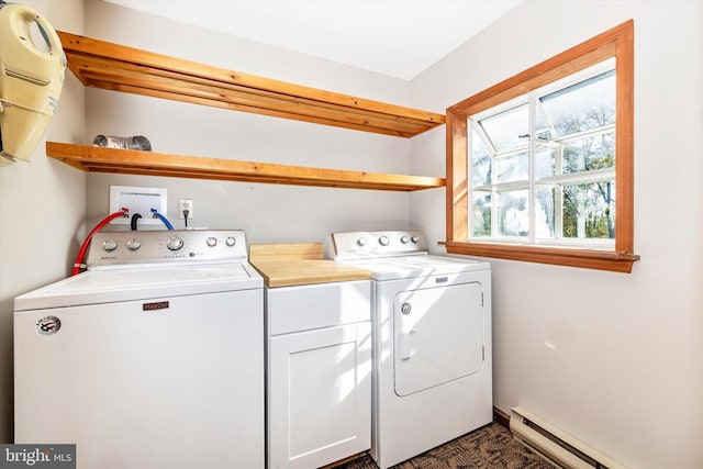 clothes washing area with a baseboard heating unit, independent washer and dryer, and cabinets