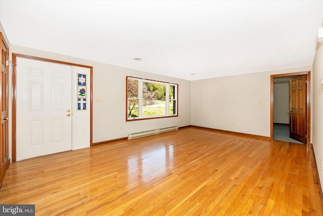 foyer entrance with baseboard heating and light wood-type flooring