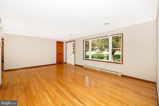 empty room with light hardwood / wood-style flooring and a baseboard radiator