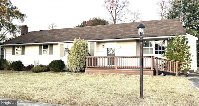 view of front of house with a front yard and a deck