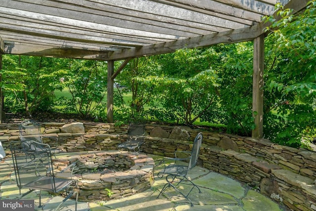 view of patio / terrace with an outdoor fire pit and a pergola