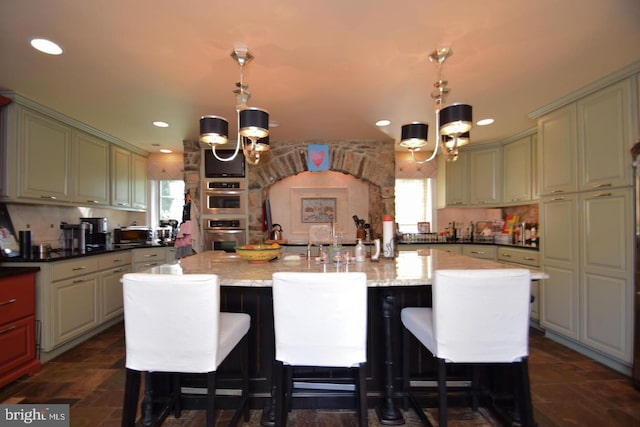 kitchen with dark stone counters, pendant lighting, and a notable chandelier