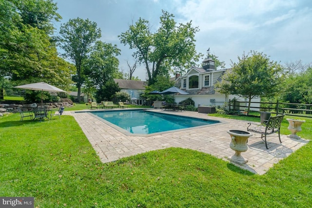 pool featuring a yard, fence, and a patio