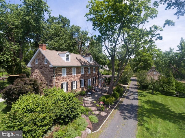 colonial inspired home with a front lawn and a chimney