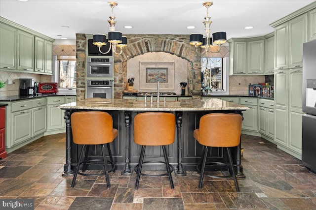 kitchen featuring a chandelier, green cabinetry, and hanging light fixtures