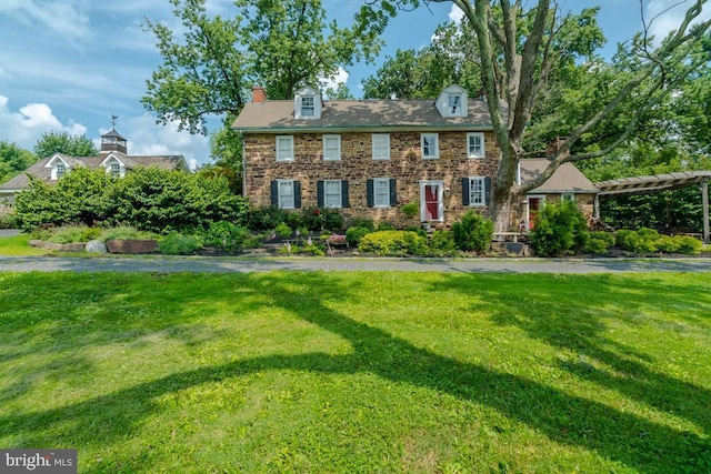 view of front of property featuring a chimney and a front yard