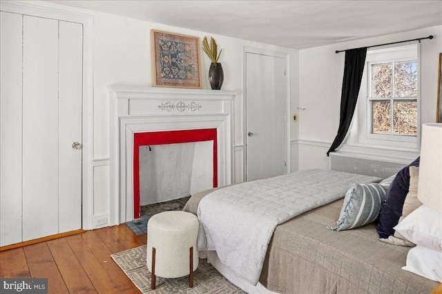 bedroom with a fireplace and wood finished floors