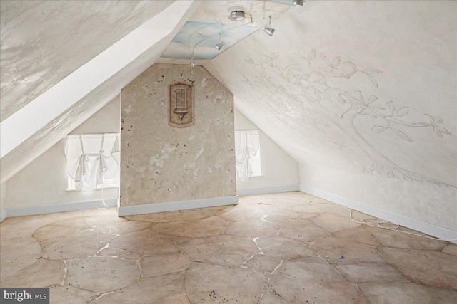 additional living space with vaulted ceiling and baseboards