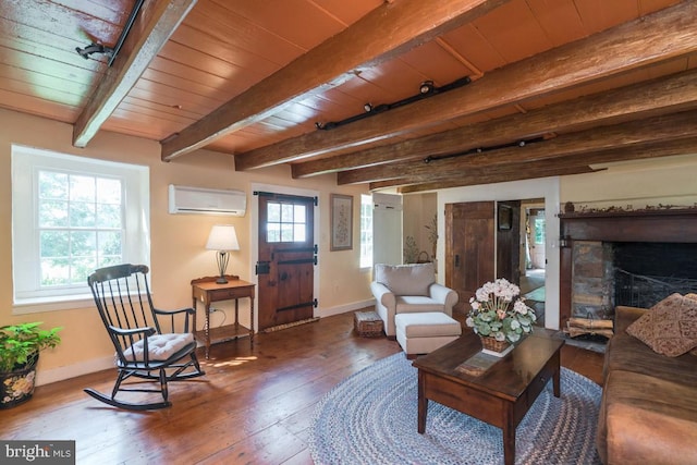 living room featuring a wealth of natural light, baseboards, an AC wall unit, and wood finished floors