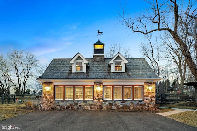 exterior space featuring stone siding and fence