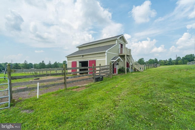 view of front of house with an exterior structure, a rural view, and an outdoor structure