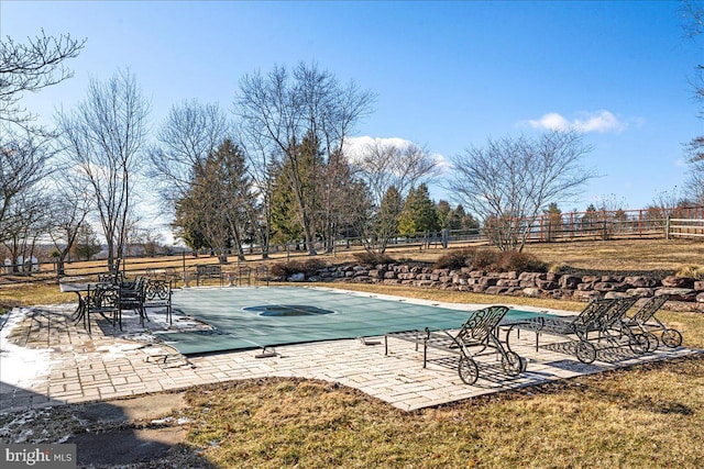 view of swimming pool with fence, a lawn, and a patio