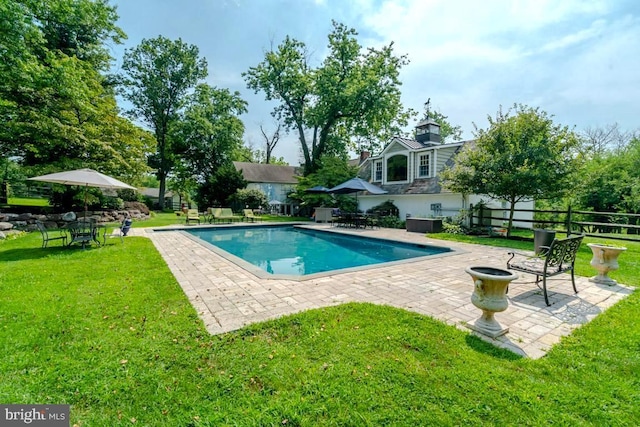 outdoor pool with a patio and a yard