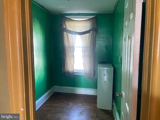 unfurnished room with dark wood-type flooring