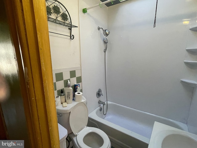 bathroom featuring toilet, bathtub / shower combination, and backsplash