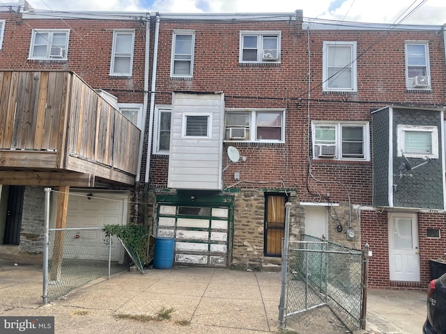 rear view of house featuring cooling unit and a garage