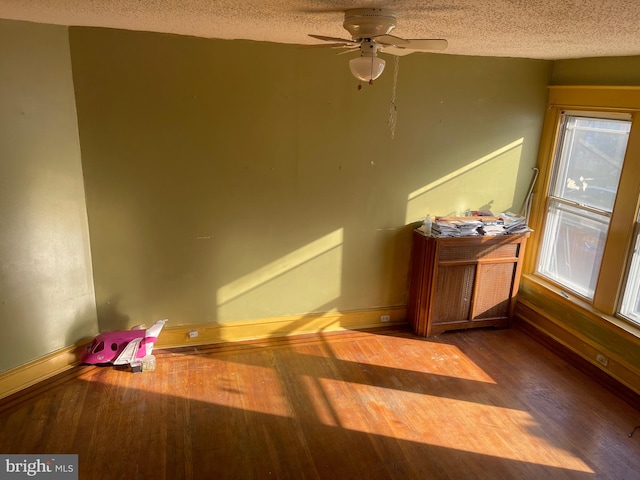 spare room with ceiling fan, a textured ceiling, and hardwood / wood-style floors