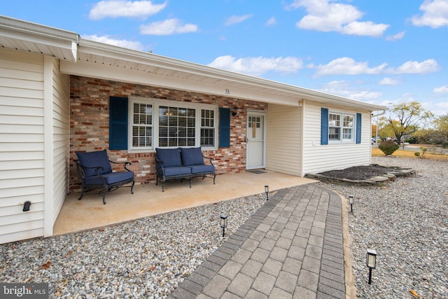 view of exterior entry with a patio