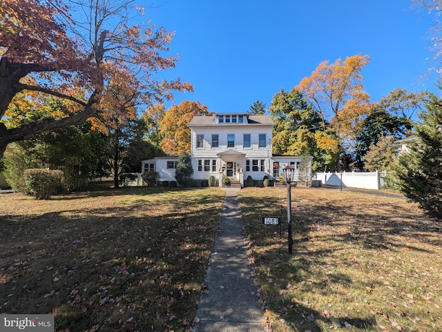 colonial-style house featuring a front yard