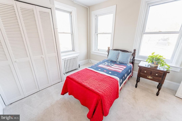 carpeted bedroom featuring a closet and radiator