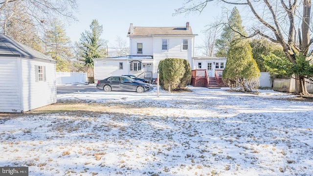 snow covered house featuring a wooden deck