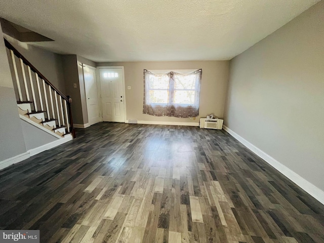 entryway with a textured ceiling and dark hardwood / wood-style floors