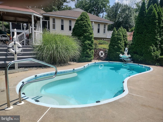 view of swimming pool featuring a patio area and a wooden deck