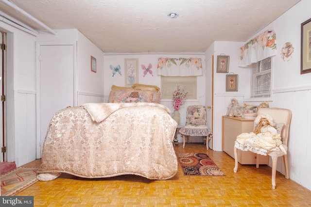 bedroom featuring a textured ceiling and parquet floors