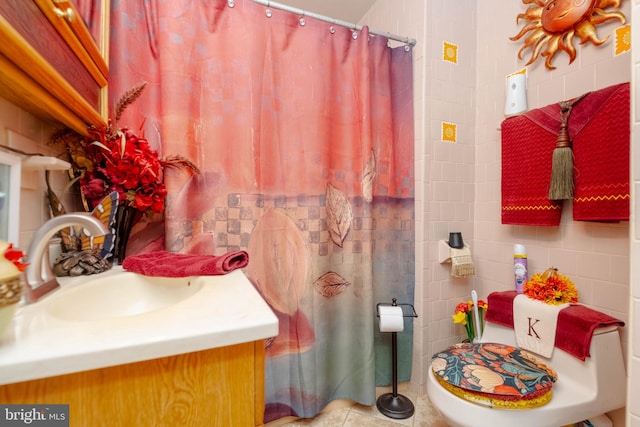 bathroom featuring tile patterned floors, toilet, tile walls, decorative backsplash, and vanity