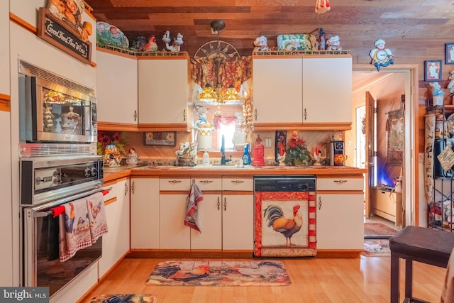 kitchen with white dishwasher, light hardwood / wood-style flooring, white cabinetry, and oven