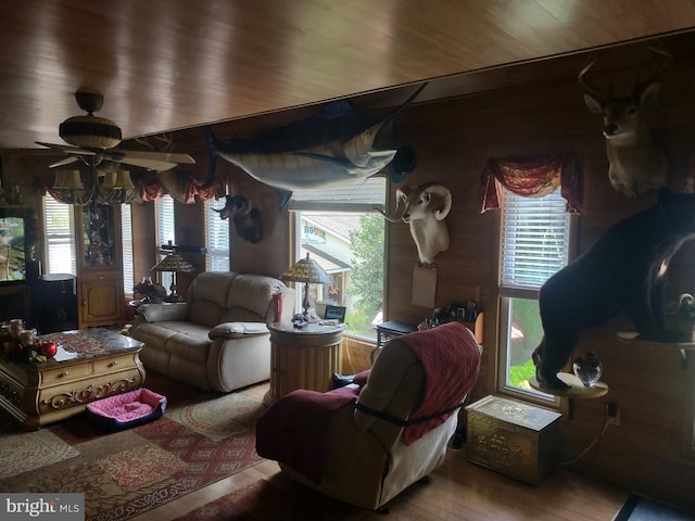 living room featuring hardwood / wood-style floors, a wealth of natural light, and wooden walls