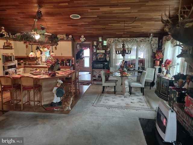 interior space with stainless steel appliances, wooden ceiling, heating unit, hanging light fixtures, and a notable chandelier