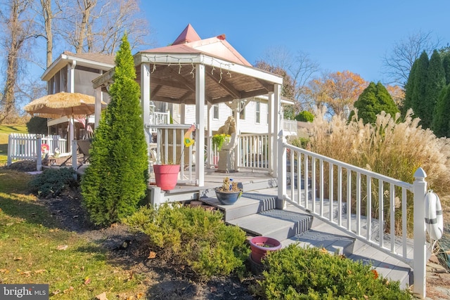 rear view of property with a wooden deck and a gazebo