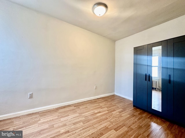 empty room with radiator and light hardwood / wood-style floors