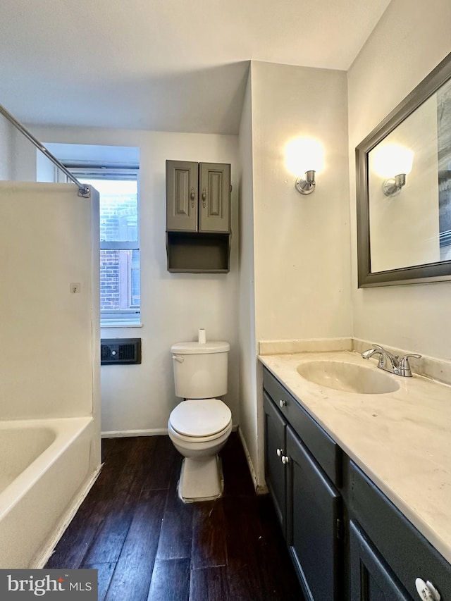 full bathroom with vanity, hardwood / wood-style floors, shower / tub combination, and toilet