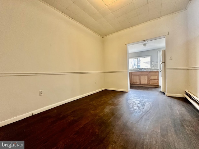 spare room featuring ornamental molding, dark hardwood / wood-style floors, and a baseboard radiator