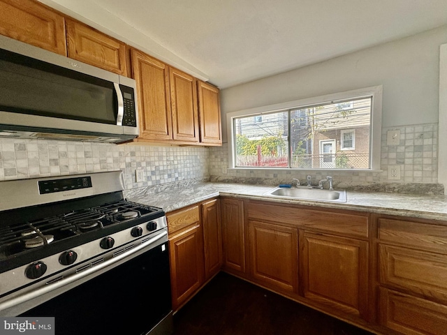 kitchen with sink, appliances with stainless steel finishes, and backsplash