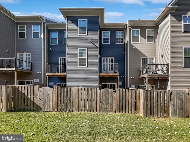 back of property with a lawn and a balcony