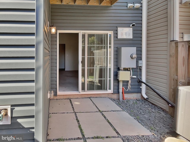 property entrance with cooling unit and a patio area