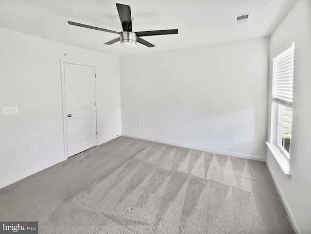 spare room featuring light colored carpet and ceiling fan