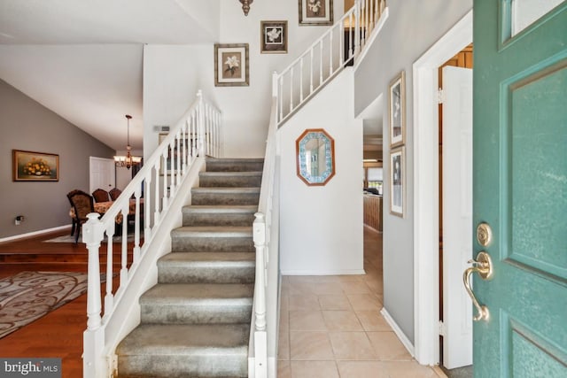 foyer with lofted ceiling, light hardwood / wood-style flooring, and an inviting chandelier