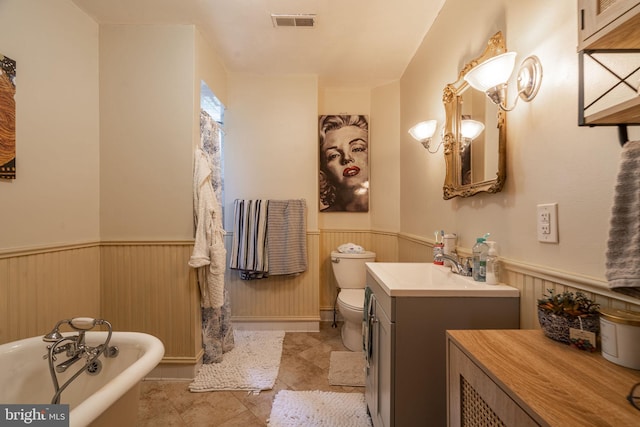 bathroom featuring vanity, toilet, tile patterned floors, and a bathing tub