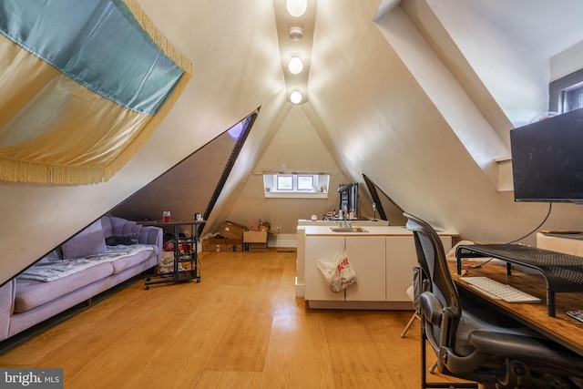 interior space with lofted ceiling and light hardwood / wood-style flooring