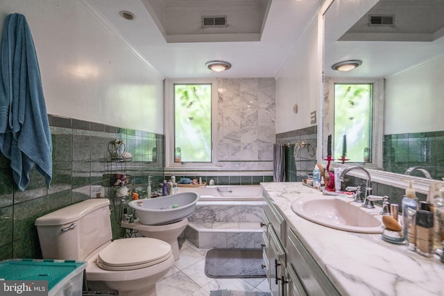 bathroom featuring toilet, plenty of natural light, tile walls, and tiled bath