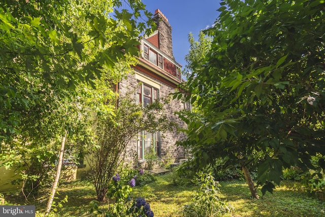 view of side of home with a yard