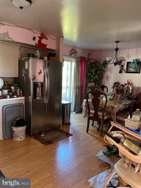 kitchen featuring a chandelier, light wood-type flooring, and stainless steel fridge