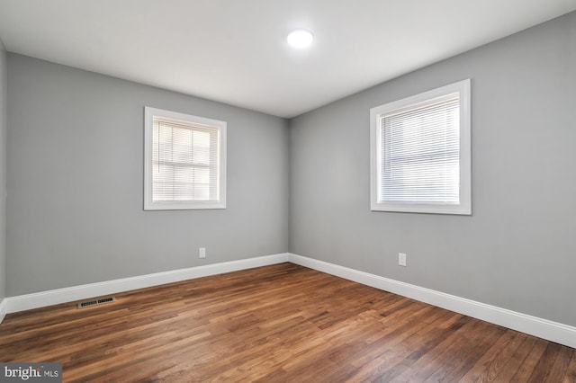 spare room featuring dark wood-type flooring