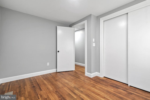 unfurnished bedroom with a closet and wood-type flooring